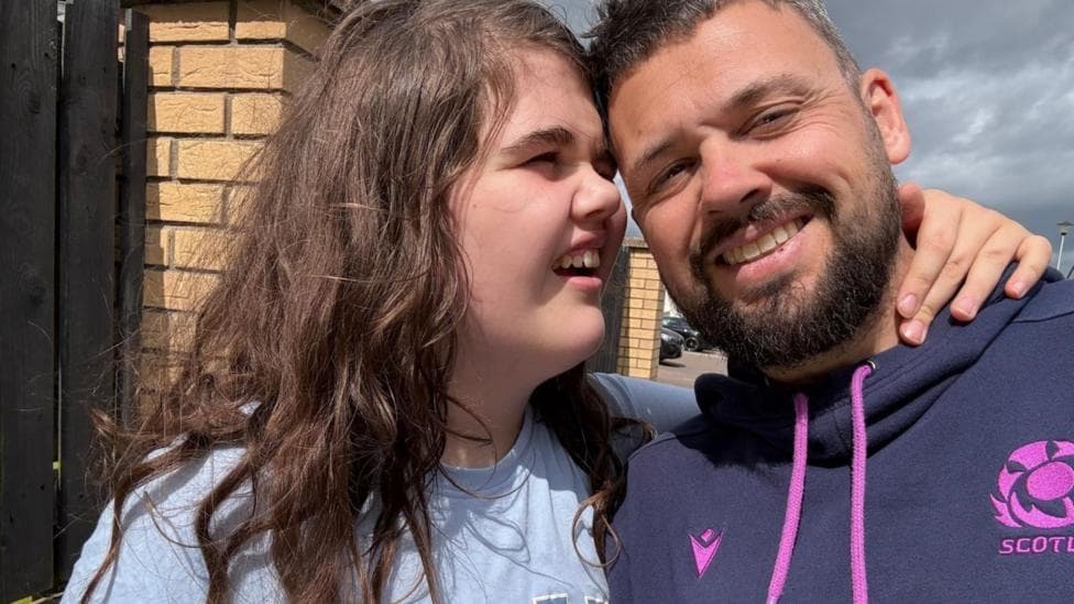 Sophie McNab and dad Iain McNab hugging. Iain is smiling straight at the camera. Sophie is looking at Iain and smiling.