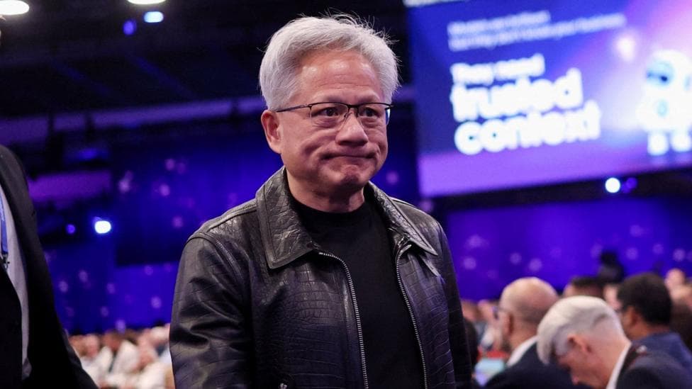 Nvidia CEO Jensen Huang walking the floor at the Salesforce "Dreamforce" conference, wearing a black leather jacket and black t-shirt.