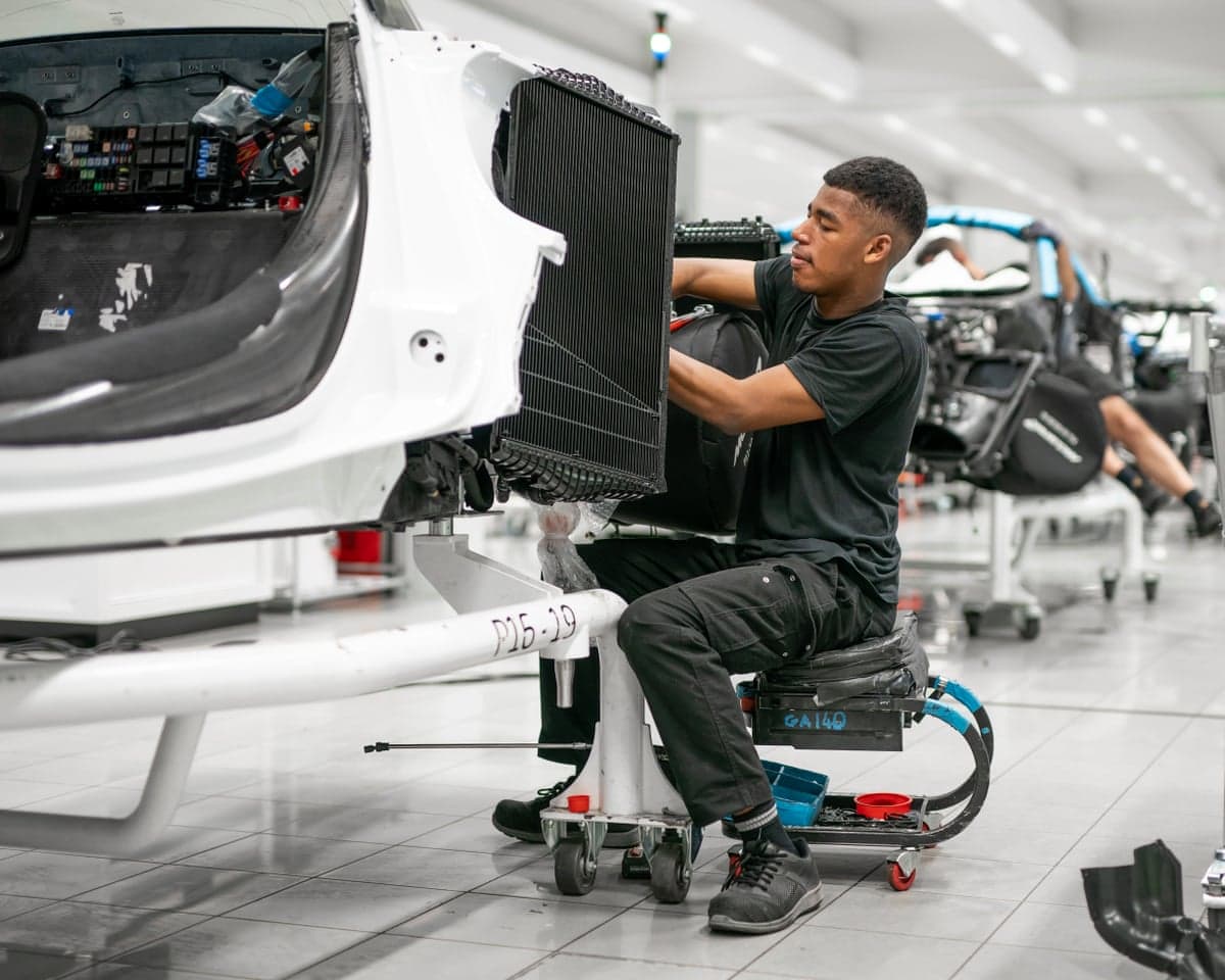 A young man is working on a car at the McLaren factory