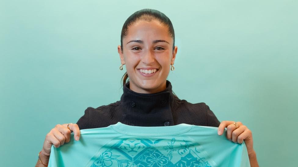 A smiling Jana Fernandez holds a London City shirt