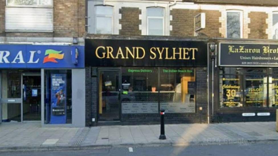 A sign outside a restaurant reading Grand Sylhet