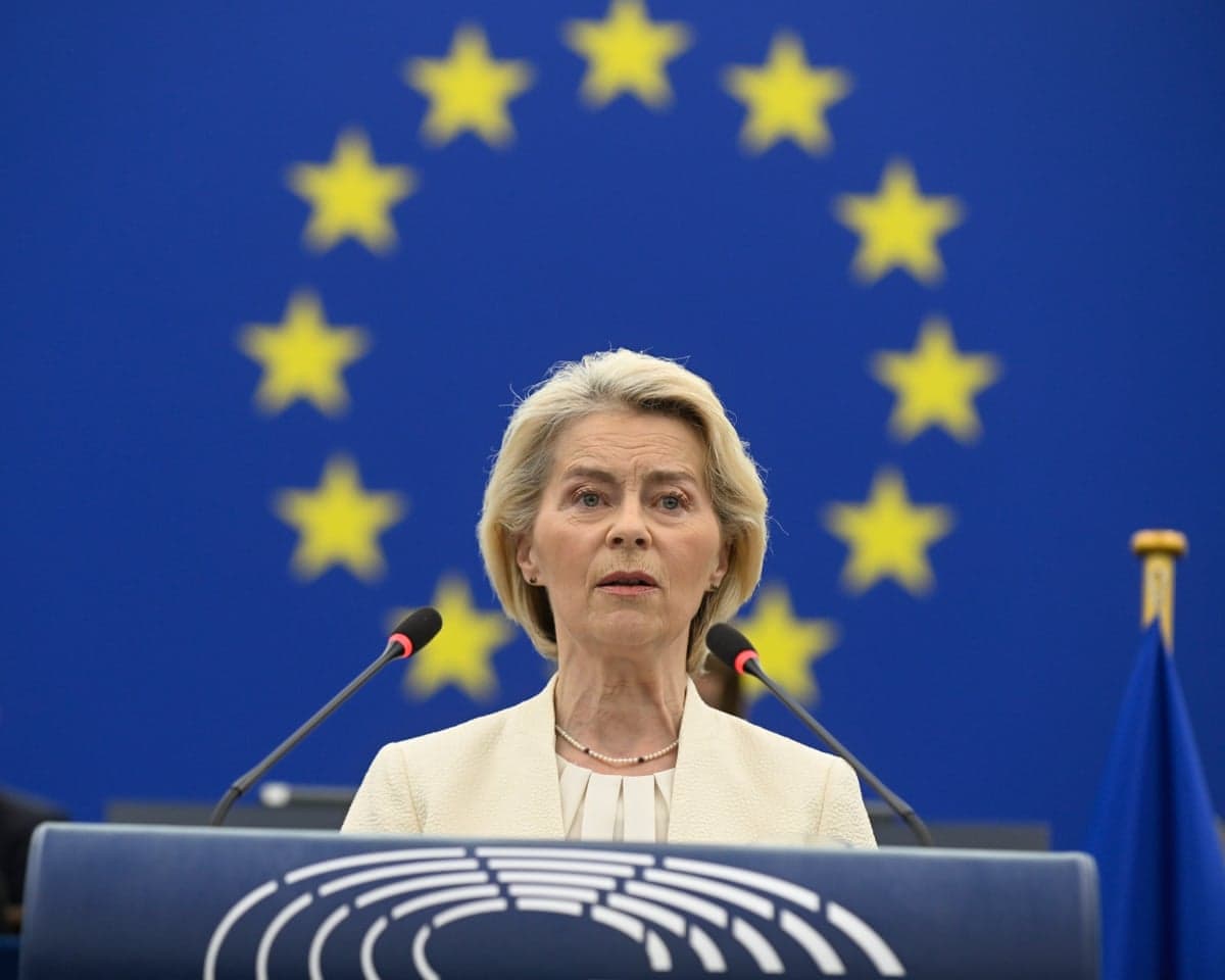 Ursula von der Leyen speaking at a lectern with the EU flag behind her