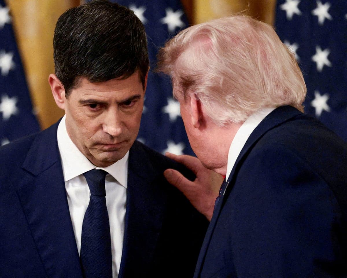 Donald Trump holds Kevin Warsh's shoulder as he speaks to him
