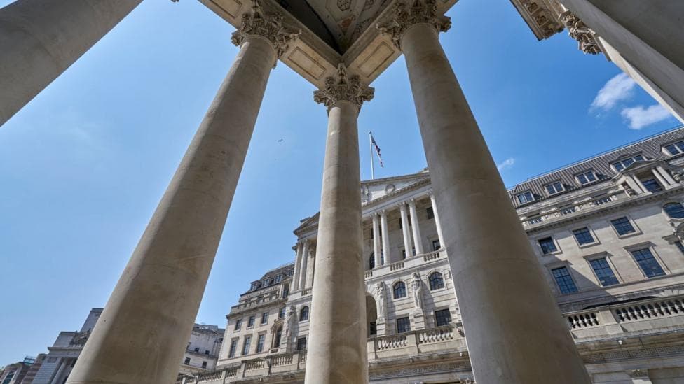 The exterior of the Bank of England with columns from a neighbouring building in the foreground.