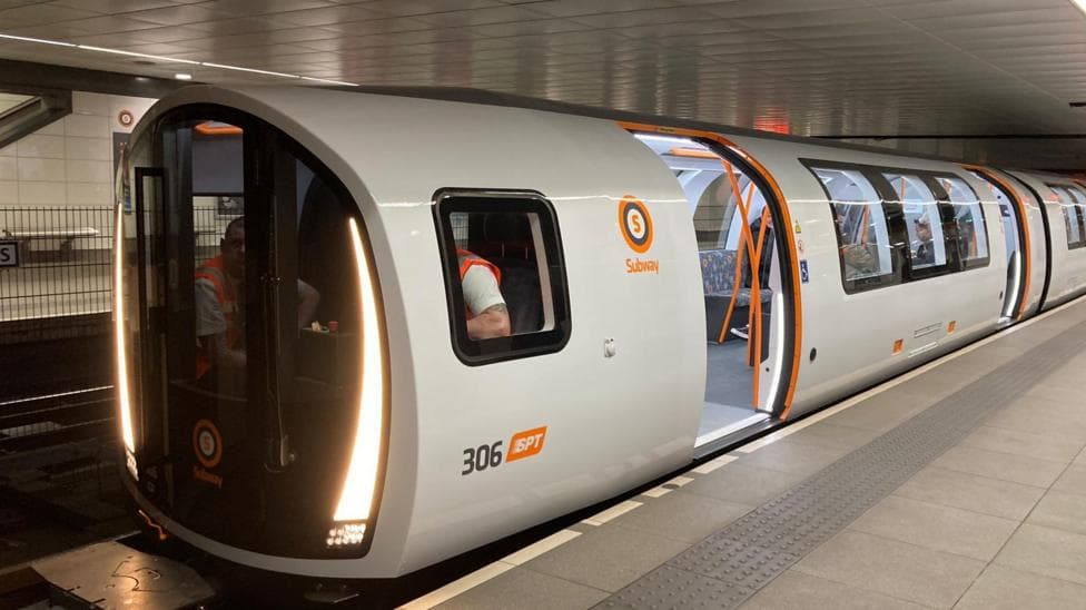 A Subway train, with doors open as it sits at a station.