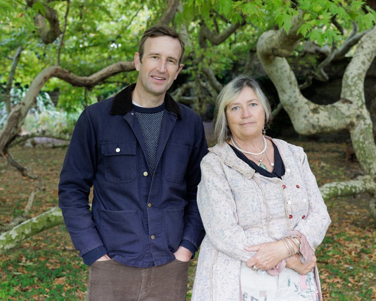 Authors Robert Macfarlane and Jackie Morris stand together outdoors before a gnarled tree