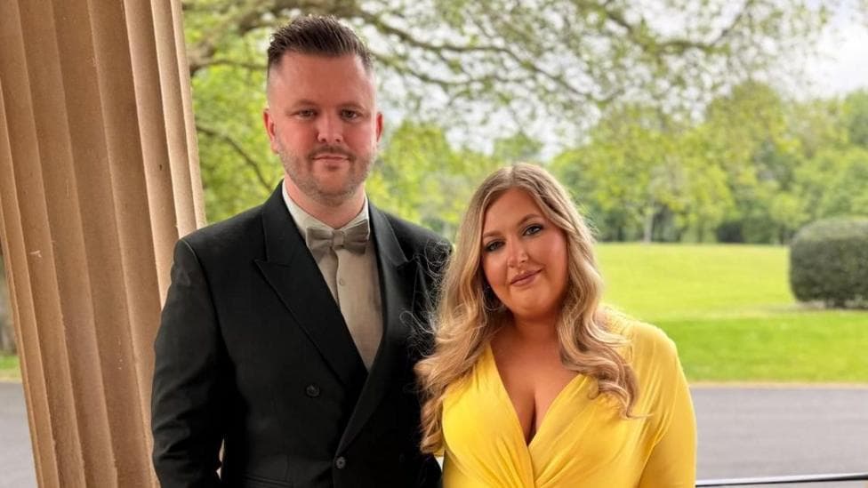 Conroy and his partner Amber dressed elegantly. He is wearing a suit with a bow tie, she is wearing a bright yellow dress.