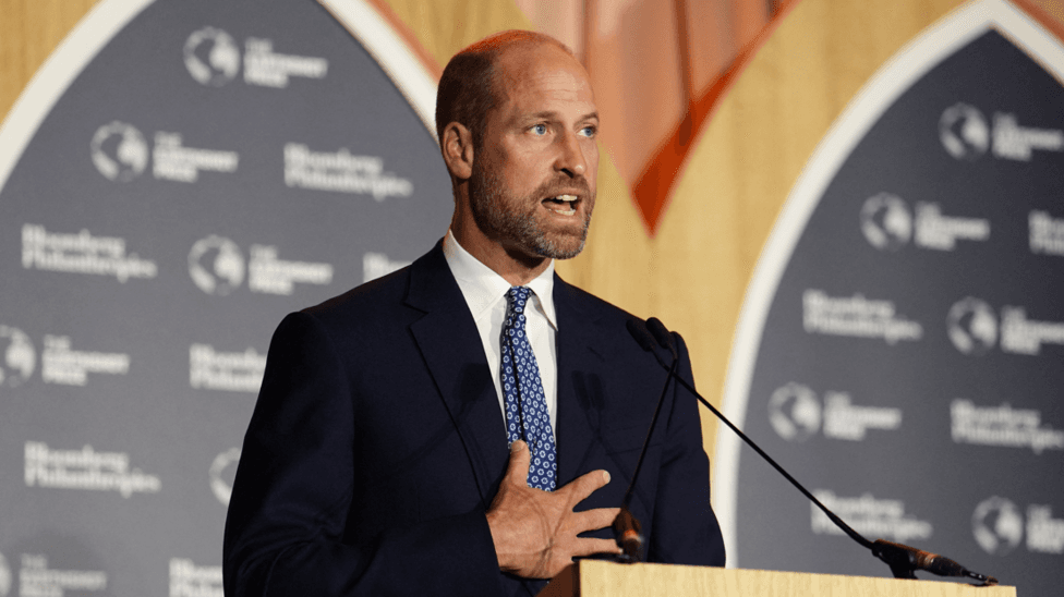 Prince of Wales, speaks at the Earthshot Prize Impact Assembly at the Guildhall in central London. He stands in a navy suit and blue tie at a lectern with a microphone