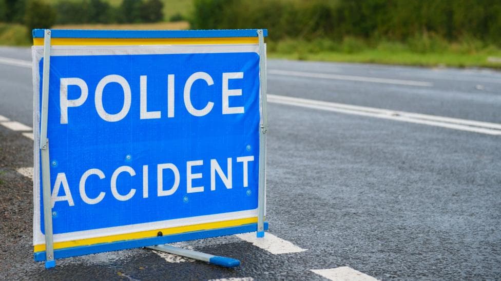 A blue and white police accident sign at the side of a dual carriageway
