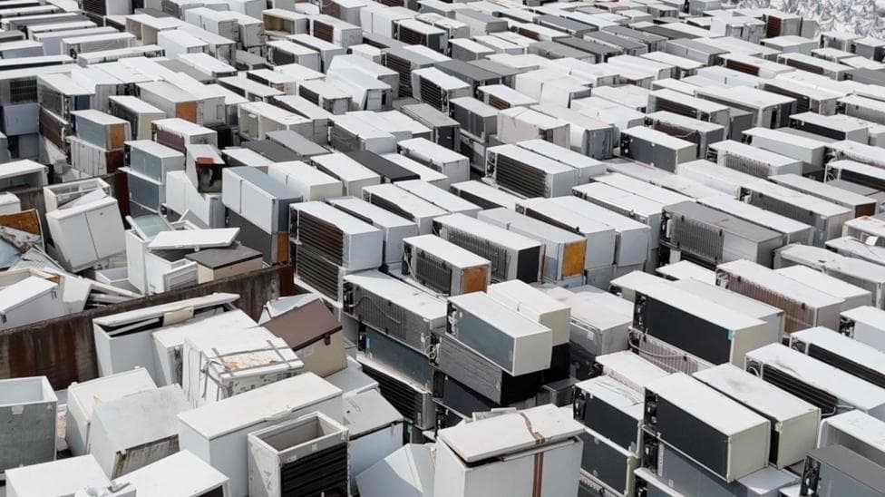 Stacks of fridges and freezer sit on top of each other in a pile.