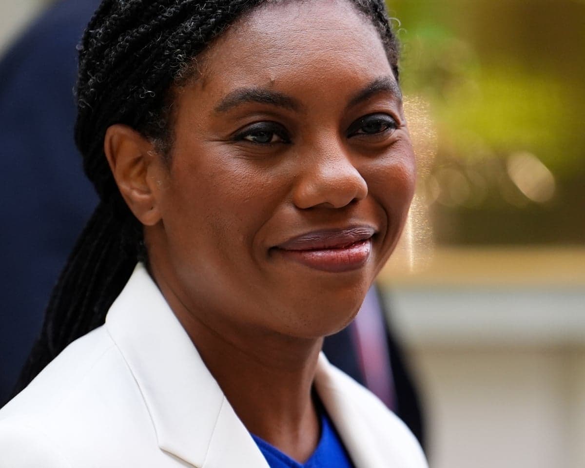 A close-up of smartly-dressed woman who is grinning slightly as she looks in the direction of the camera.