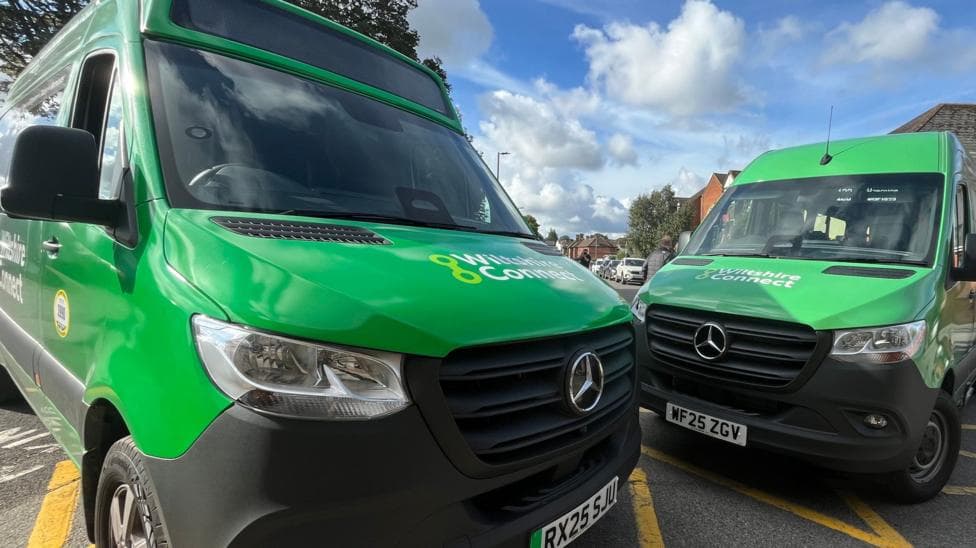 Two green minibuses parked up at an angle next to each other. Both have Wiltshire Connect written across their bonnets.