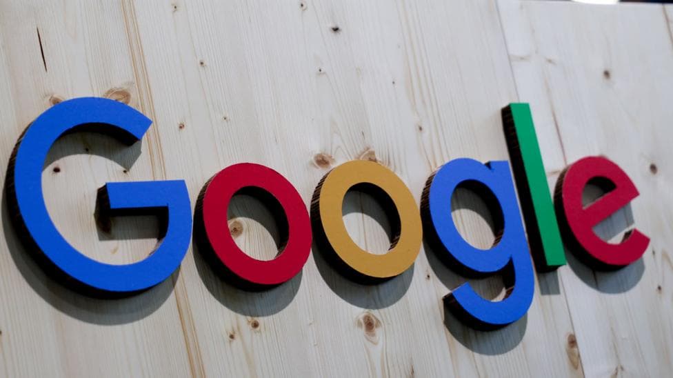 The word 'Google' is stuck to a plain wooden surface, the letters in simple font and in block colours blue, red, yellow and green.