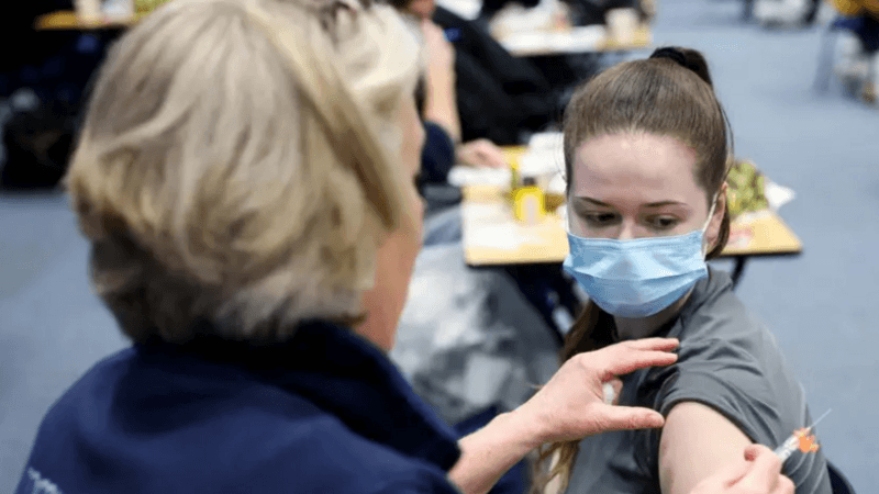 A teenager is getting her meningitis vaccine