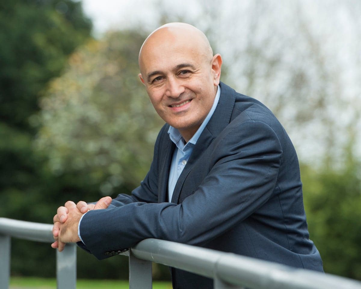 Prof Jim Al-Khalili wearing a dark blue suit jacket, light blue shirt and no tie