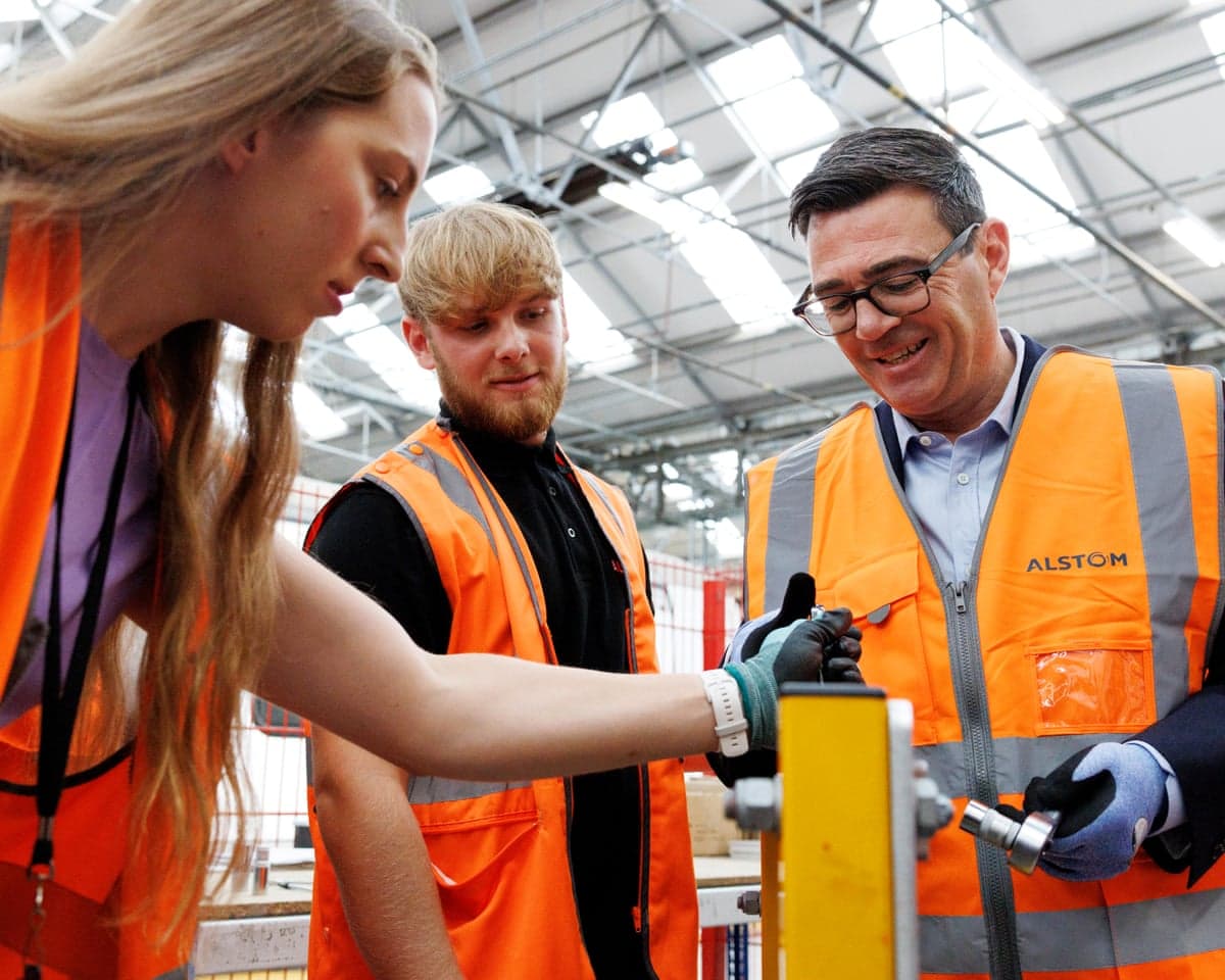 A young woman, a young man and Anyd Burnham all wearing high vis jackets and protective gloves.