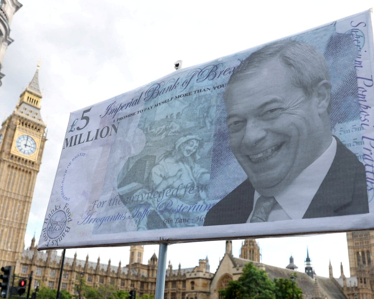 A protest placard shows a giant banknote with Nigel Farage's face, near Big Ben
