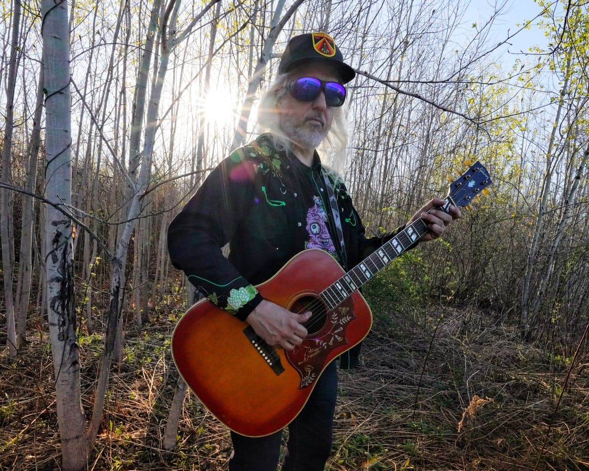 J Mascis playing guitar in a wood