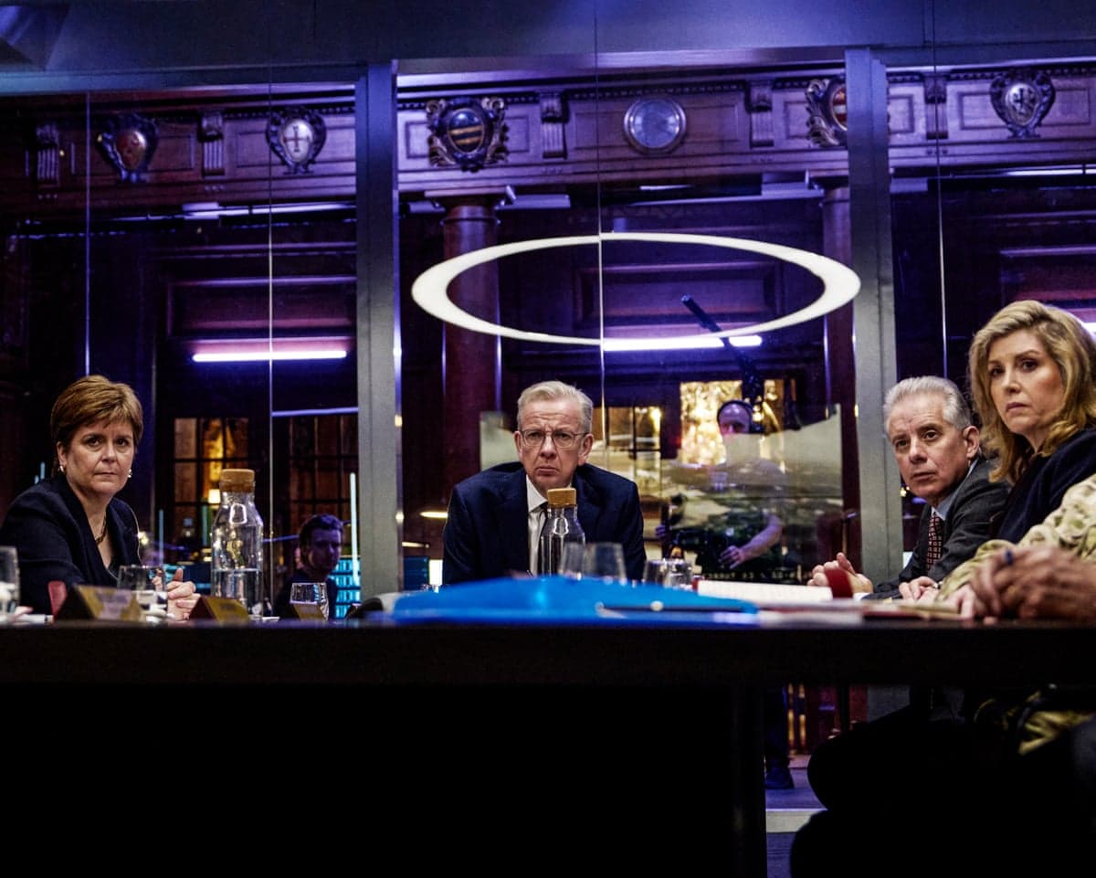 Ministers and strategists sit around a table in a tense simulated crisis meeting