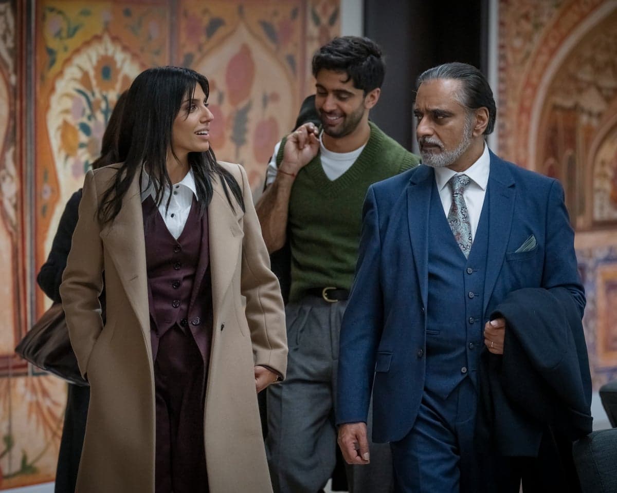 Aria, Kav and Dhruv walk together through an ornately decorated hallway in a scene from The Split Up.