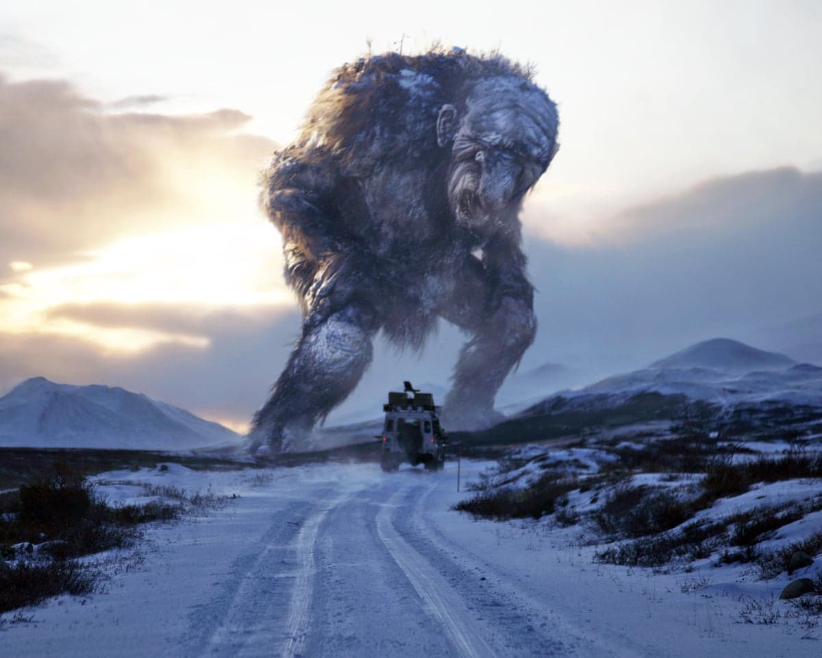 Movie still showing the troll Jötunn towering over a vehicle on a snowy road