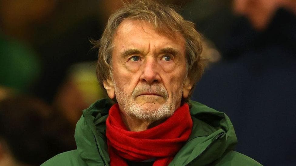 Sir Jim Ratcliffe in a green coat and red scarf