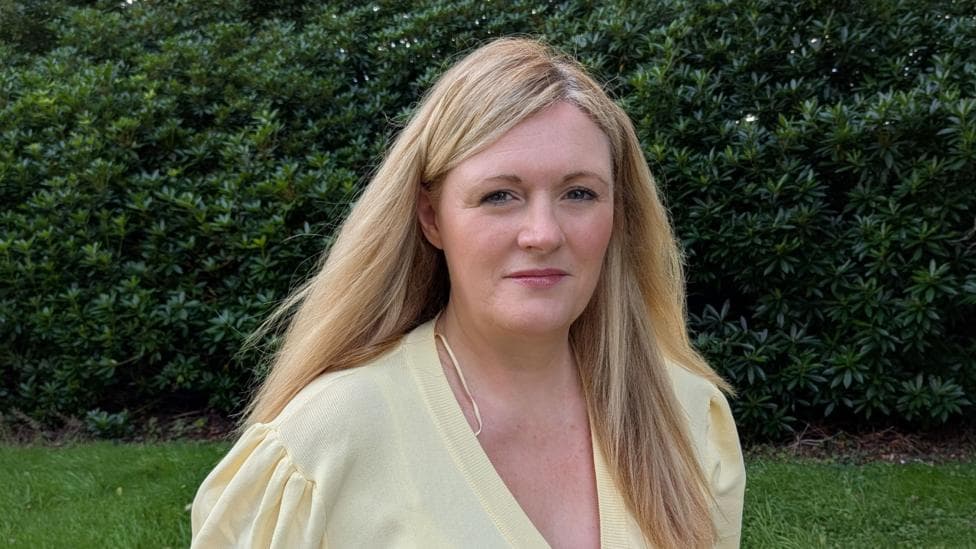 Shows a woman with blonde hair and wearing a yellow top