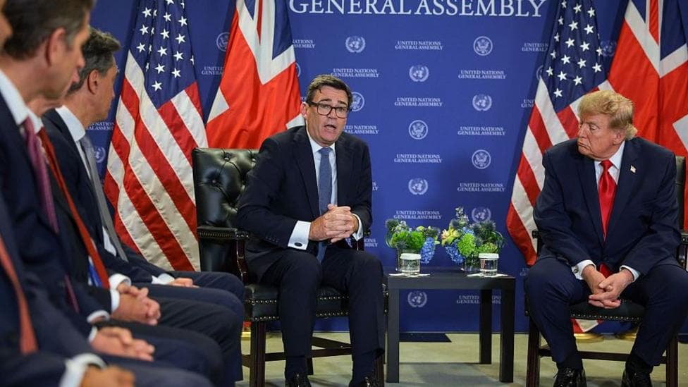 Burnham and Trump are centred seated in front of a UN General Assembly banner, lined by top US and UK foreign officials watching on.