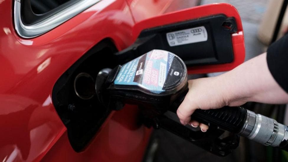 A woman fills a car with diesel from the pump