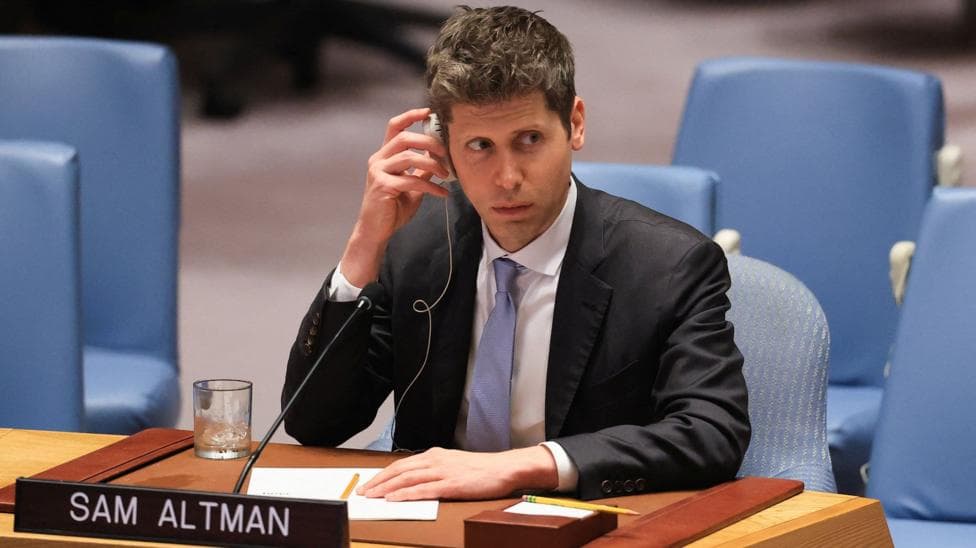 Sam Altman of OpenAI sitting before the US Security Council wearing a suit and tie while listening to a translation of comments.