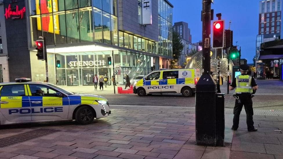 Police vehicles and officers outside the St Enoch Centre in Glasgow at night