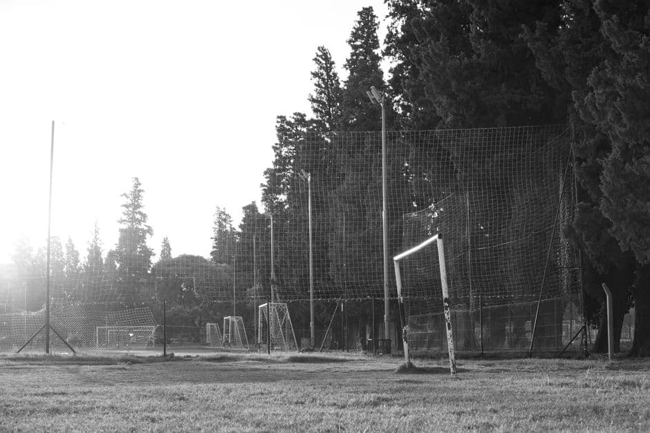 Black and white photo of a rustic football field in Córdoba, Argentina at sunrise.