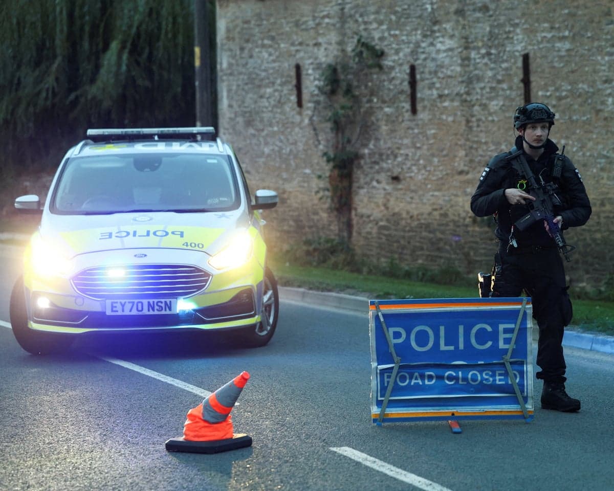 Armed police officer near a police car
