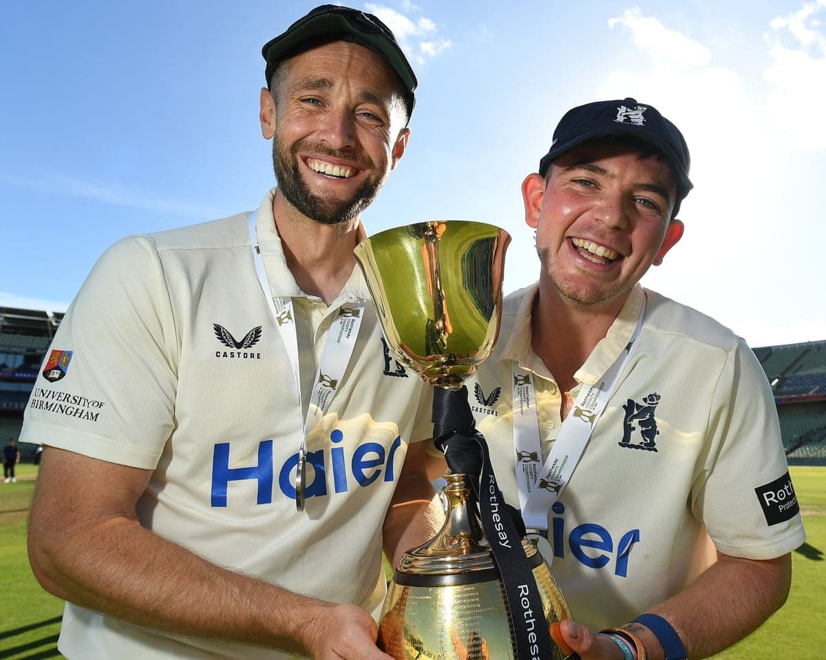 Chris Woakes (left) and Ethan Bamber of Warwickshire smile as they hold the County Championship trophy