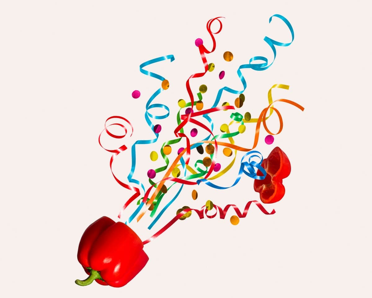 An illustration of colourful ribbons and confetti burst upward from an opened red bell pepper.