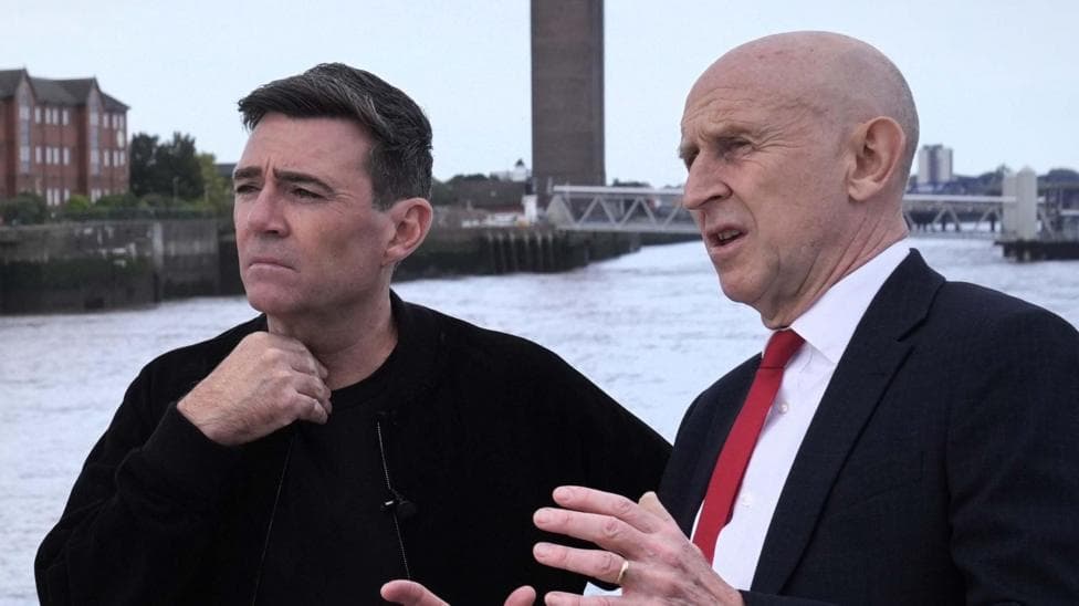 John Healey makes a point with his hands to a thoughtful looking Andy Burnham, who is gazing out across the Mersey river on a ferry in Liverpool