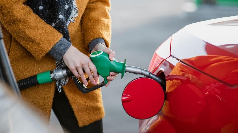 A woman fills up her car with fuel