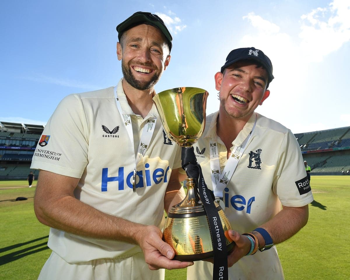 Chris Woakes and Ethan Bamber show off the County Championship trophy