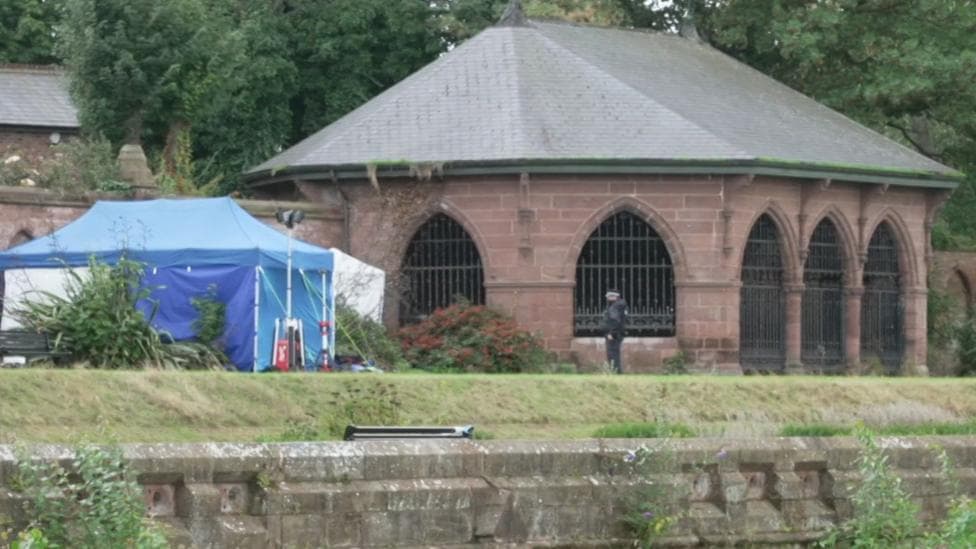 A blue police scenes of crime tent in Stanley Park near the walled garden where the body was found.