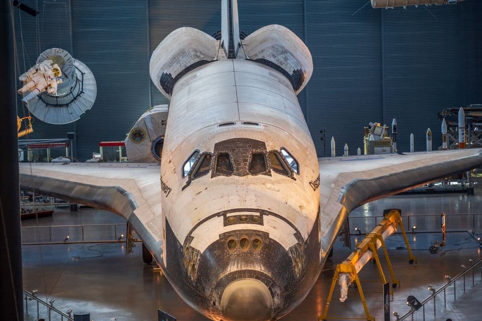 Detailed front view of a space shuttle on display in a museum exhibit, showcasing its design.