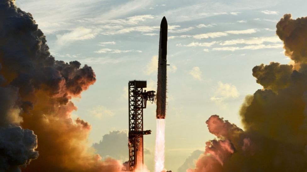 A Space X rocket blasting off from a launch site surrounded by smoke from the exhaust