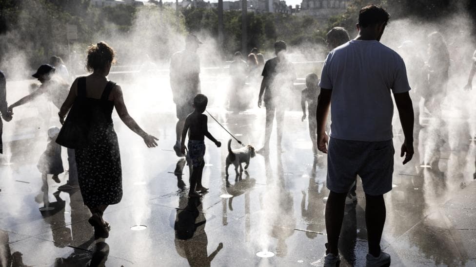 People walk across jets of water in a public square in Paris