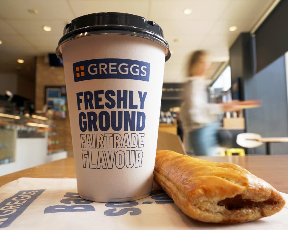 A Greggs sausage roll and hot drink at a branch of Greggs