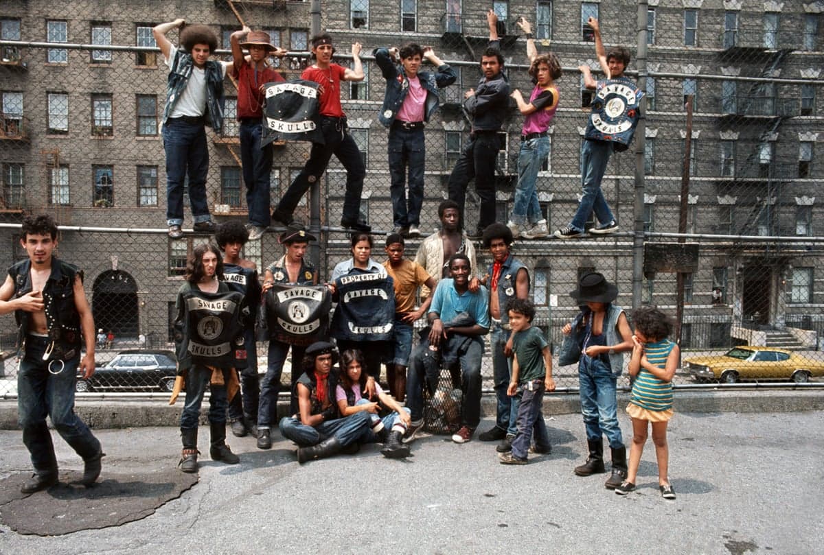 Members of the "Savage Skulls" gang pose on and around a fence in the street, by photographer Jean-Pierre Laffont