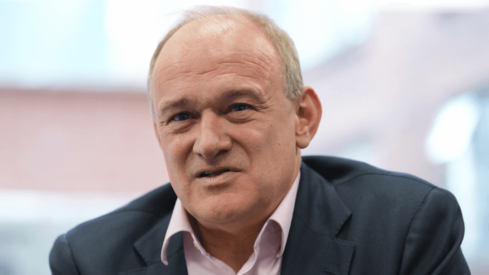 Ed Davey wearing a dark grey suit and a pink shirt