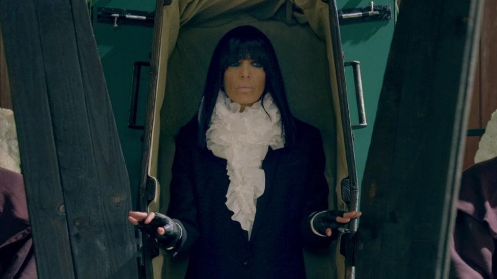 Claudia Winkleman emerging from a coffin