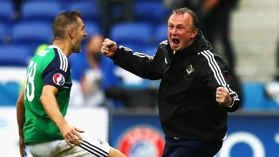 Michael O'Neill celebrates with Aaron Hughes