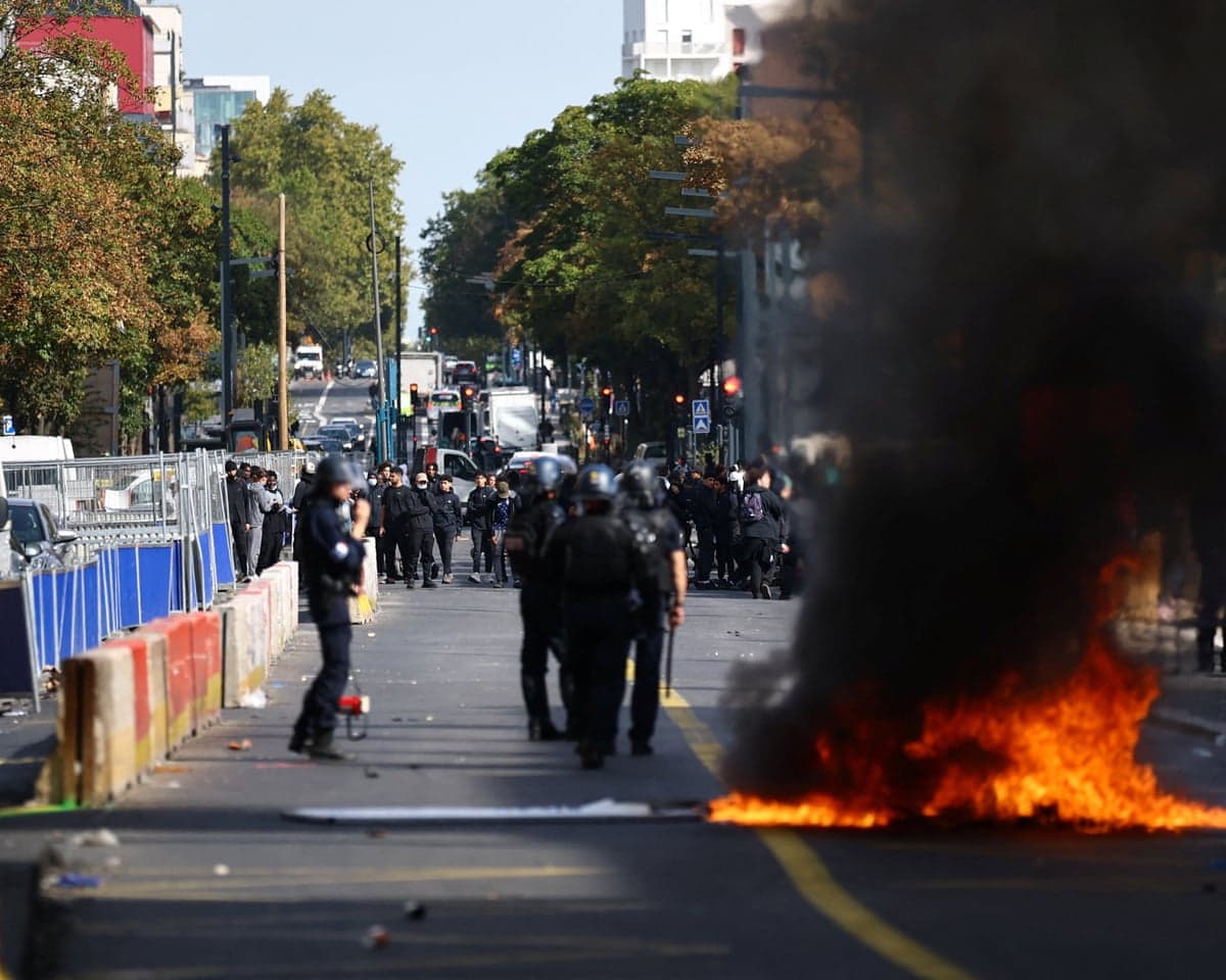 French gendarmes stand in position next to burning roadworks amid clashes in a street during a protest by high school students near the Lycee Berthelot high school in Aubervilliers as part of nationwide protests.
