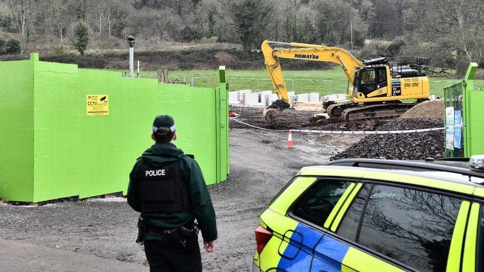 A picture of the scene, it shows police standing back from where a digger is