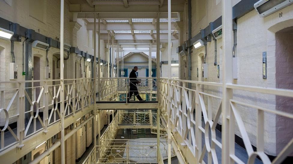 A prisoner officer walks along a balcony in HMP Portland, Dorset.